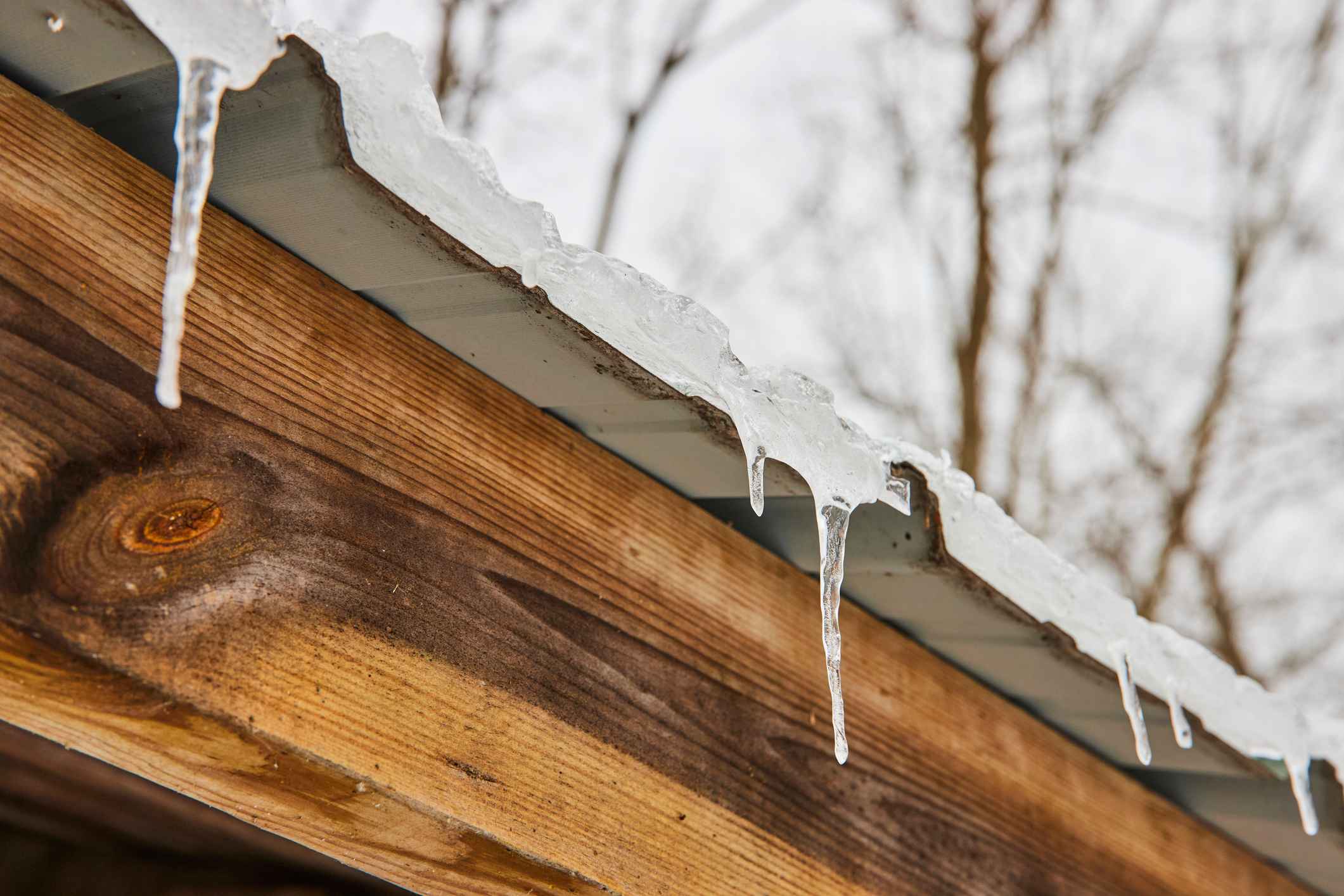 winter icicles dangling from a roof, frozen weather
