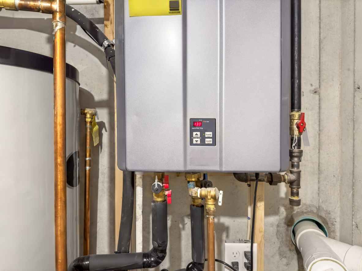 Tankless hot water heater, set to 130° F, connected to a recirculation system and storage tank